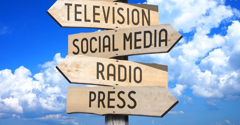 Multi-directional sign with arrows that say Television, Social Media, Radio and Press